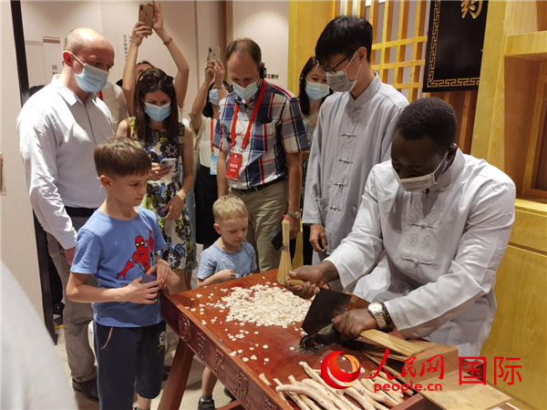 上合组织传统医学论坛外宾参观团考察江西中医药大学并观看传统医药制作过程。人民网记者 张博岚摄