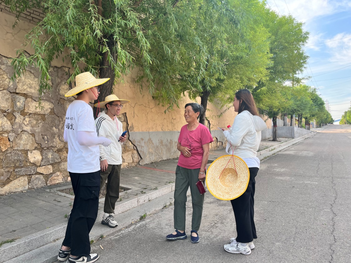 国土整治与生态修复实践调研团师生与村民交流。校方供图