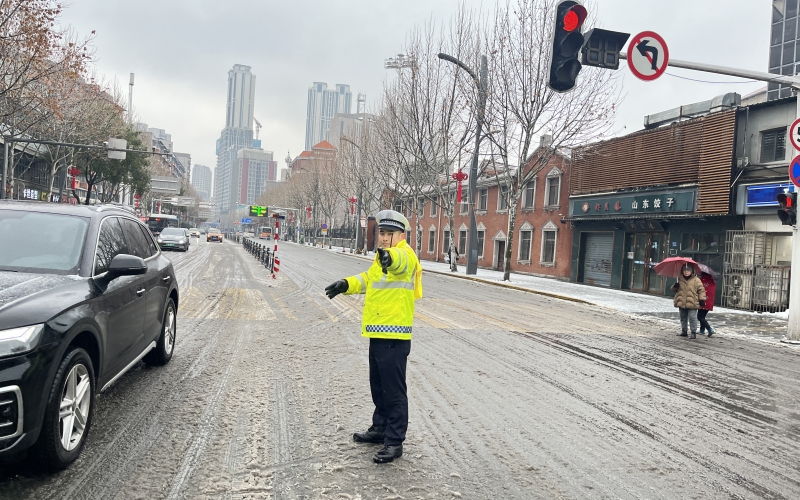 武汉交警迎风战雪 持续“护航”。