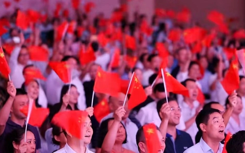 现场观众随着音乐挥舞手中旗帜。郧宣文摄