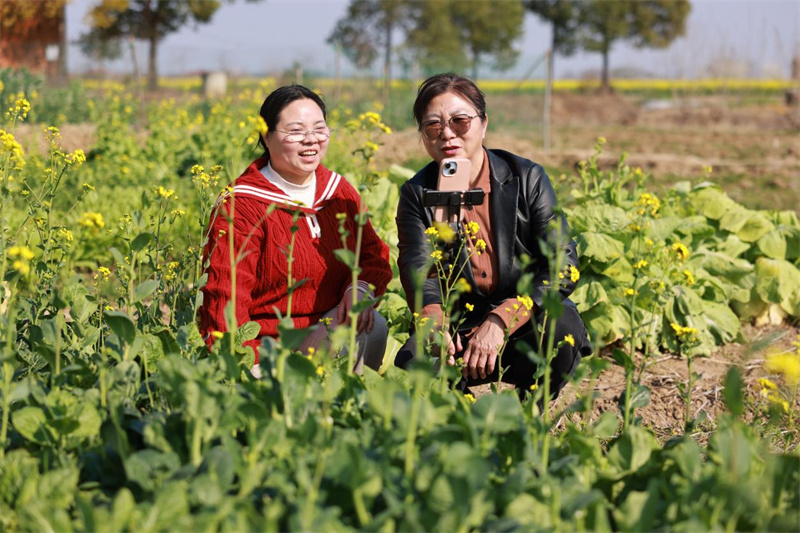 张幼萍指导村民李晓琴开展网络直播，让乡村土特产“出圈”，拓宽农民增收渠道。