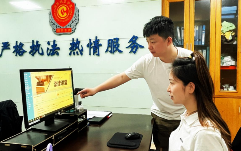 青年市场稽查员刘晓阳与同事探讨市场检查中的专卖法律适用细节。张沛供图