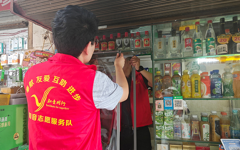 志愿者为银发零售户安装推拉防蚊帘。