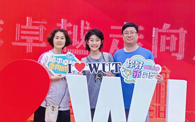 新生邵馨锐在打卡墙与父母合影。
